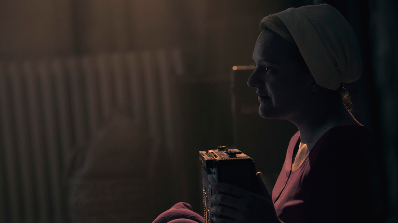 June (Elisabeth Moss) listens to some music before recording a secret message for Luke.